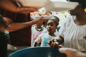 Child receiving a meal at a food distribution